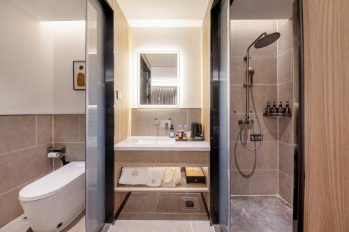 a bathroom with a toilet and a sink and a shower at Yifang Apartment Guangzhou in Guangzhou