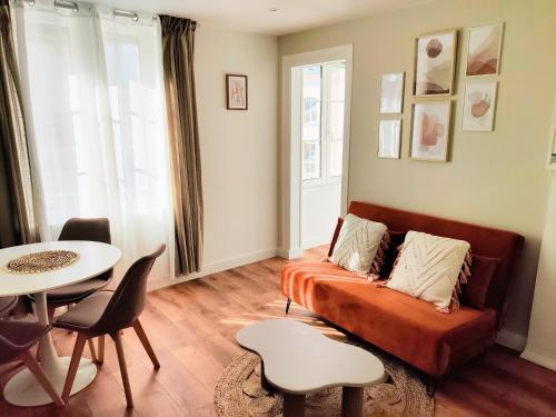 een woonkamer met een bank en een tafel bij Cocon de Charme en Hyper centre in Lisieux