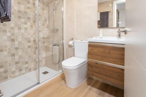 a bathroom with a toilet and a shower and a sink at Apartamento Tamarindos 500 in L'Estartit