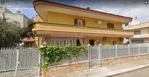 a house with a fence in front of it at Villa Felice in Porto Cesareo