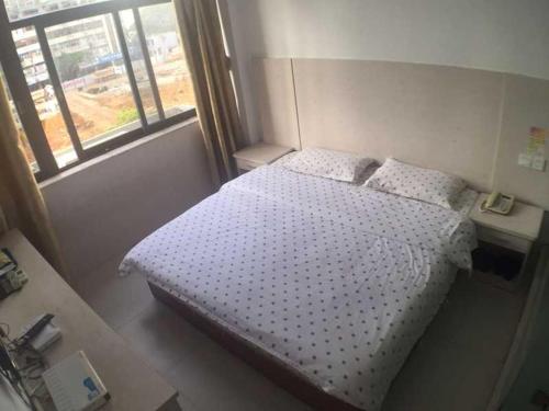 - une petite chambre avec un lit et une fenêtre dans l'établissement Seven Orange Hotel, à Shenzhen