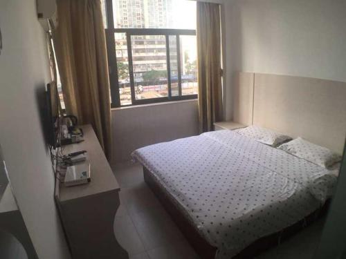 Habitación pequeña con cama y ventana en Seven Orange Hotel, en Shenzhen
