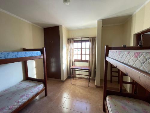 a room with three bunk beds and a window at Casa de Retiros Virgen de Guadalupe, Finca la Soledad. Bodega Prelatura in Santa María