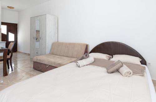 1 cama blanca grande en una habitación con silla en Tea, en Herceg-Novi