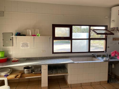 eine Küche mit einem Waschbecken und einem Fenster in der Unterkunft Casa de Retiros Virgen de Guadalupe, Finca la Soledad. Bodega Prelatura in Santa María