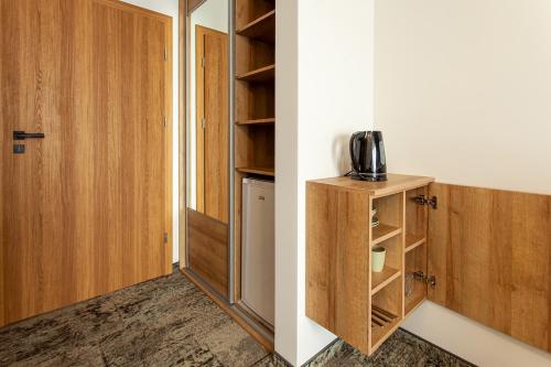 a room with a closet with wooden cabinets and a door at Bursztynowa Przystań in Grzybowo
