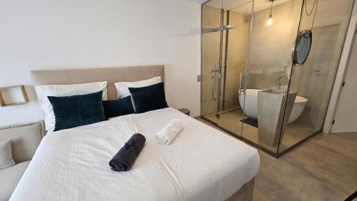 een slaapkamer met een groot wit bed en een douche bij Oasis jacuzzi retreat in Marbella