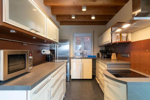 a large kitchen with white cabinets and stainless steel appliances at Traumwohnung mit 5 Schlafzimmern in Wörrstadt