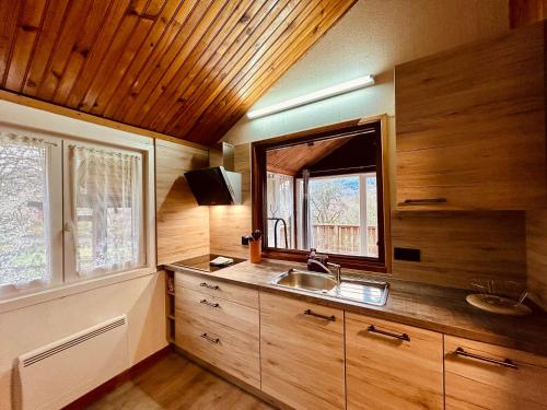 a kitchen with a sink and a mirror in a room at Au Chalet d'Aline - Atypique pour 4 personnes in Gérardmer
