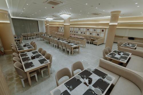 an overhead view of a dining room with tables and chairs at Hotel Maroon in Godhra