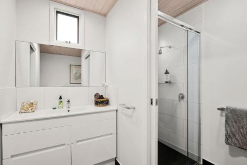 a white bathroom with a sink and a shower at Coastwalk in Aireys Inlet
