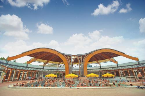 a large building with a crowd of people in it at Apartman Hotel in Bük