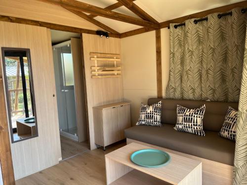 a living room with a couch and a table at Ri-Veu corse dans camping marina di sorbo in Sorbo-Ocagnano