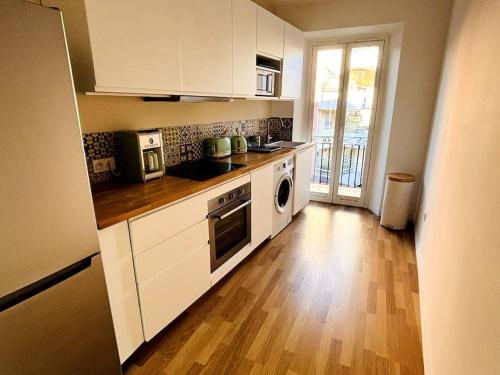 une cuisine avec des appareils blancs et un parquet dans l'établissement Spectaculaire 1B & balcons, à Nice