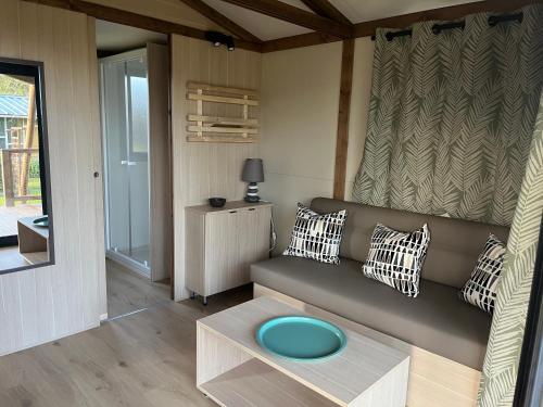 a living room with a couch and a table at Ri-Veu corse dans camping marina di sorbo in Sorbo-Ocagnano