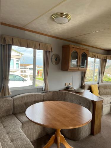 ein Wohnzimmer mit einem Sofa und einem Tisch in der Unterkunft Holiday Home by the sea in Aberystwyth