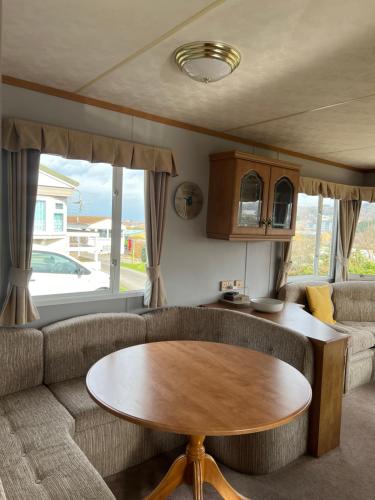 a living room with a couch and a table at Holiday Home by the sea in Aberystwyth