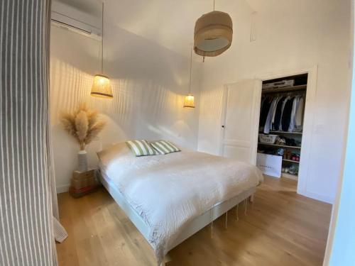 - une chambre blanche avec un lit dans l'établissement Villa Genêts - 3 suites parentales avec terrasse et piscine - Proche plage, à Gujan-Mestras