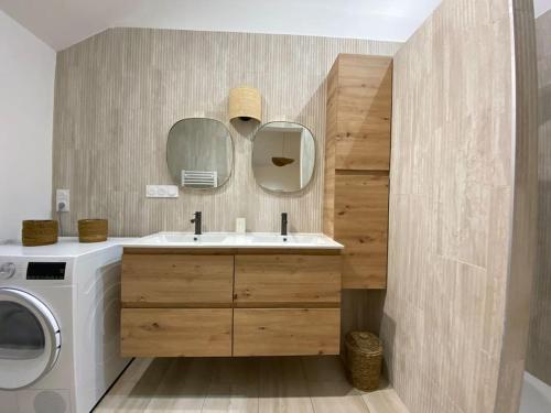 une salle de bain avec un lavabo et une machine à laver dans l'établissement Villa Genêts - 3 suites parentales avec terrasse et piscine - Proche plage, à Gujan-Mestras