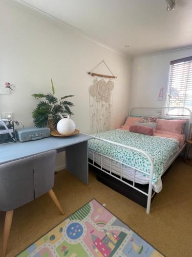 1 dormitorio con cama, escritorio y escritorio en Enchanted Retreat, en Morwell
