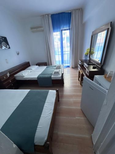 a hotel room with two beds and a window at Pansion Angela in Skiathos Town