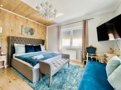 a bedroom with a bed and a couch and a tv at IrányBerény Rezidencia in Balatonberény