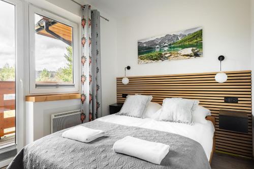 une chambre avec un lit avec deux oreillers dessus dans l'établissement Apartamenty Krzeptowskiego 2 Zakopane, à Zakopane