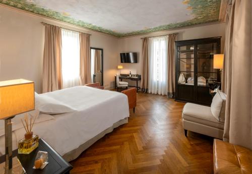 a bedroom with a bed and a desk and a chair at Villa Pattono Relais in Costigliole dʼAsti