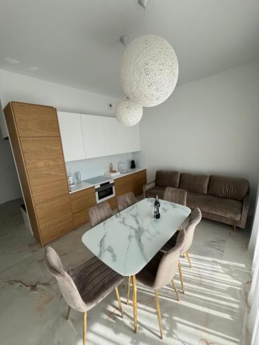 a kitchen and dining room with a table and chairs at Apartament Dziwnów White & Gold in Dziwnów