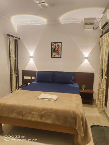 - une chambre avec un lit bleu dans l'établissement Nest Inn, à Pondichéry