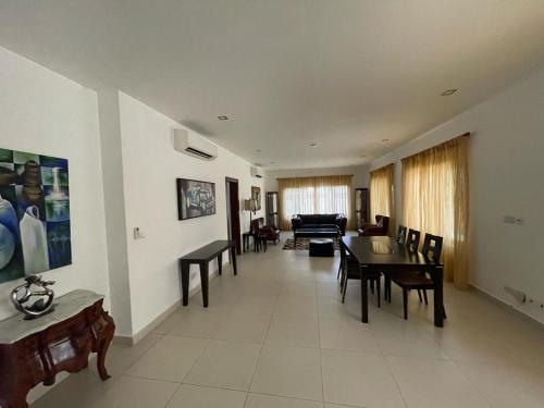 un ampio soggiorno con tavolo e sedie di Ultramodern 2 bedroom space Available a Accra