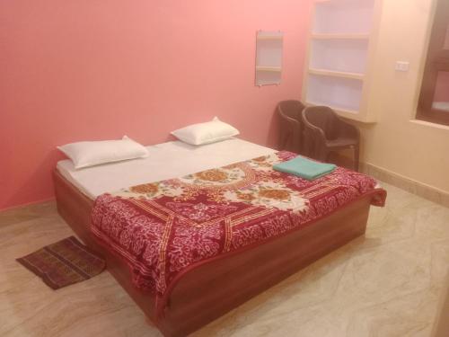 sypialnia z łóżkiem w pokoju z różowymi ścianami w obiekcie Aanand Bhwan dharmshala ayodhya w mieście Ayodhya