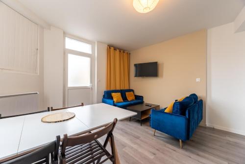 - un salon avec une table et deux chaises bleues dans l'établissement Maison 4 ch, idéal déplacement pro, parking, rénové, à Rouen