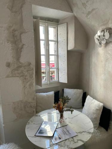 une table blanche avec un vase de fleurs sur elle dans l'établissement Le Cocon - 3 étoiles, à Annecy