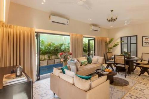 a living room with two couches and a table at Casa Felix · Luxurious 3bhk villa in Colva in Goa