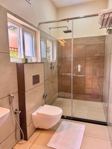 a bathroom with a shower and a toilet and a sink at Flower Valley Plantation Homestay in Munnar