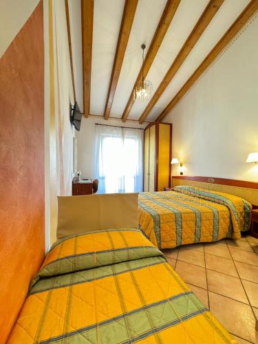 a room with two beds and a window at Hotel Romantic in Cavaion Veronese