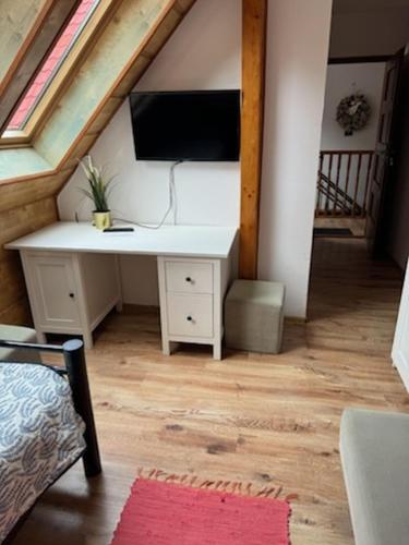 a desk in a attic with a tv on it at ZACISZE in Karłów