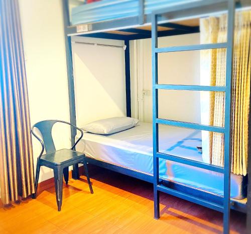 a bedroom with a bunk bed and a chair and a ladder at Three Hostel at Night Market Pakchong in Ban Sao Thong