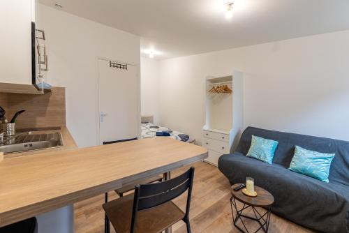 Il comprend une cuisine et un salon doté d'un canapé bleu. dans l'établissement Studio cosy, idéal déplacement pro, rénové, à Rouen