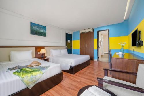 a hotel room with two beds and a television at Bantique Hotel in Da Nang