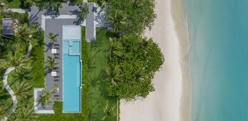 eine Draufsicht auf eine Villa mit Swimmingpool neben dem Strand in der Unterkunft Centara Reserve Samui in Chaweng