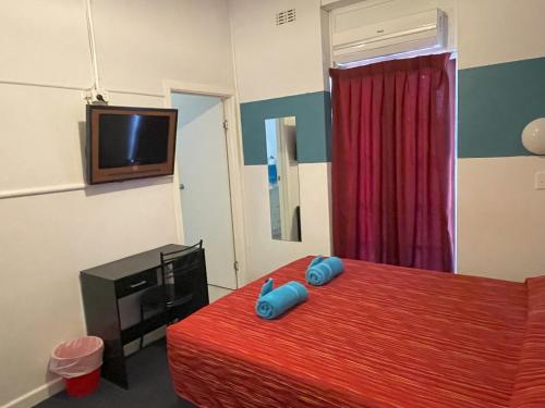 a bedroom with a bed with blue pillows on it at North Gregory Hotel in Winton