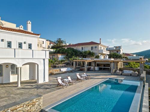 eine Villa mit einem Pool und einem Haus in der Unterkunft Androspremiumvillas in Ándros