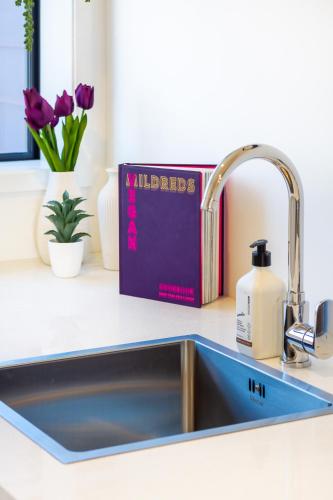 a book sitting next to a kitchen sink at Central City Charm: Pet-Friendly Studio in Christchurch