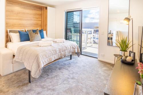 a bedroom with a bed and a balcony at Central City Charm: Pet-Friendly Studio in Christchurch