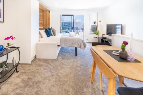 a bedroom with a bed and a living room at Central City Charm: Pet-Friendly Studio in Christchurch