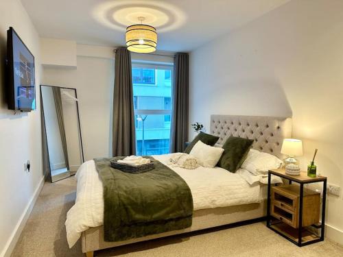 a bedroom with a large bed with a large window at Mulberry House in Stevenage
