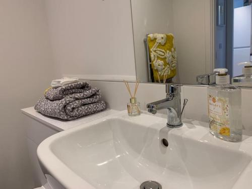 a white sink in a bathroom with a mirror at Mulberry House in Stevenage