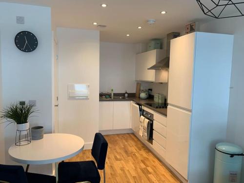 a kitchen with a table and a clock on the wall at Mulberry House in Stevenage